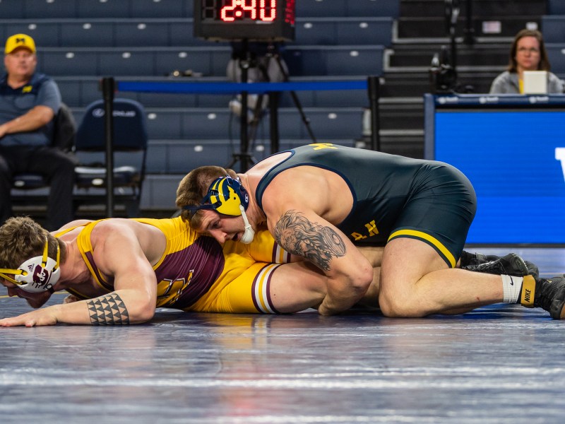 Mason Parris grabs both of his opponent's legs and holds them under his body as his opponent struggles to escape.