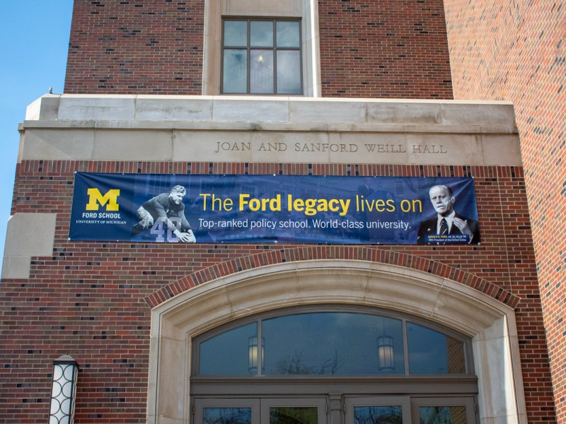 The entrance of the Ford School building with a blue banner hanging above the doorway.