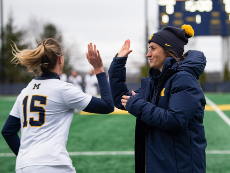 Head Coach Hannah Nielsen high-fives Maya Rutherford before the start of the game.