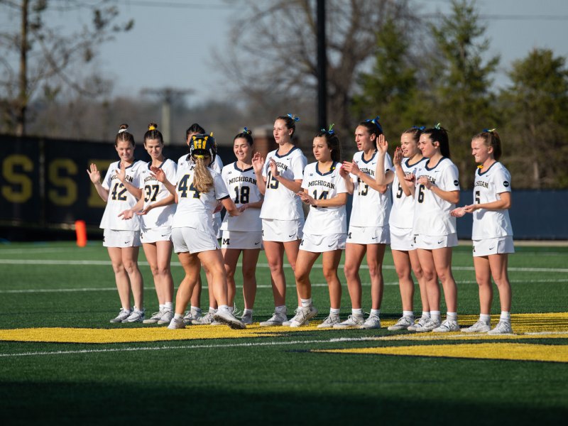 The women's lacrosse team stands in a line on the field's Block M.